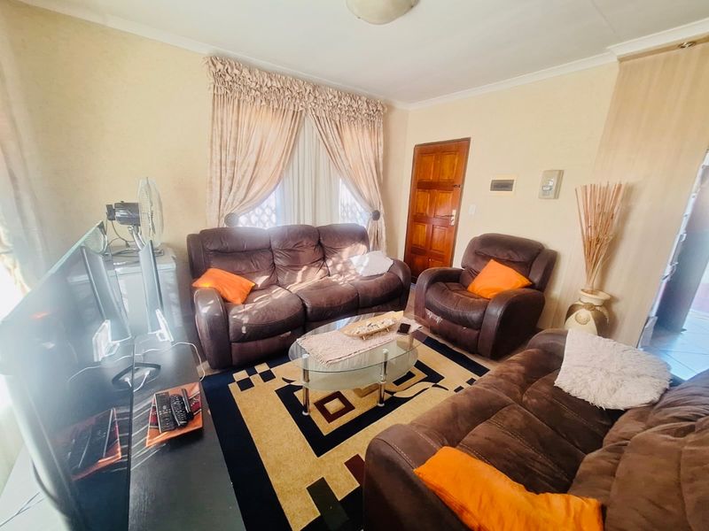 A comfortable living room featuring a coved ceiling and a solid timber door, providing a functional and traditional living space.