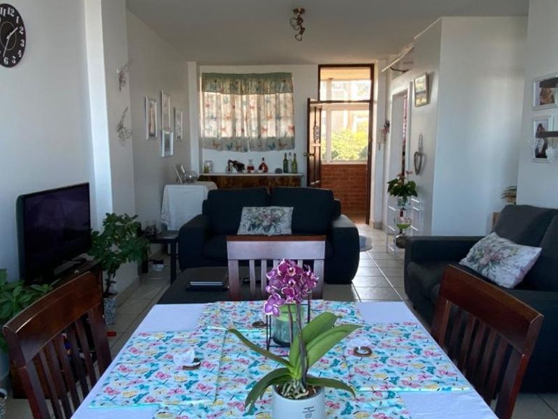 Open plan living and dining area featuring ceramic floor tiles and direct access to an outdoor balcony space.