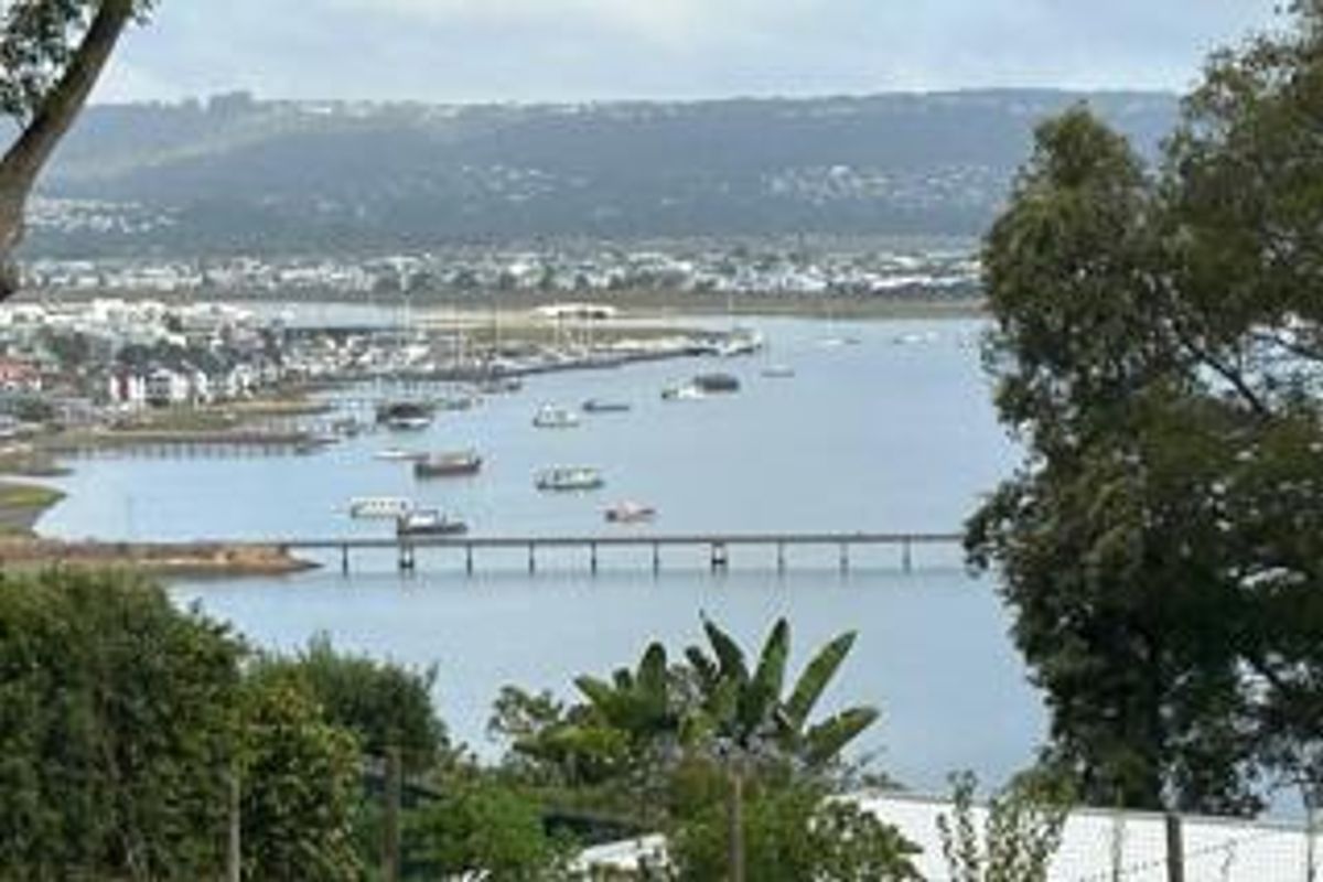 A scenic elevated view overlooking the estuary, bridge, and surrounding coastal landscape.