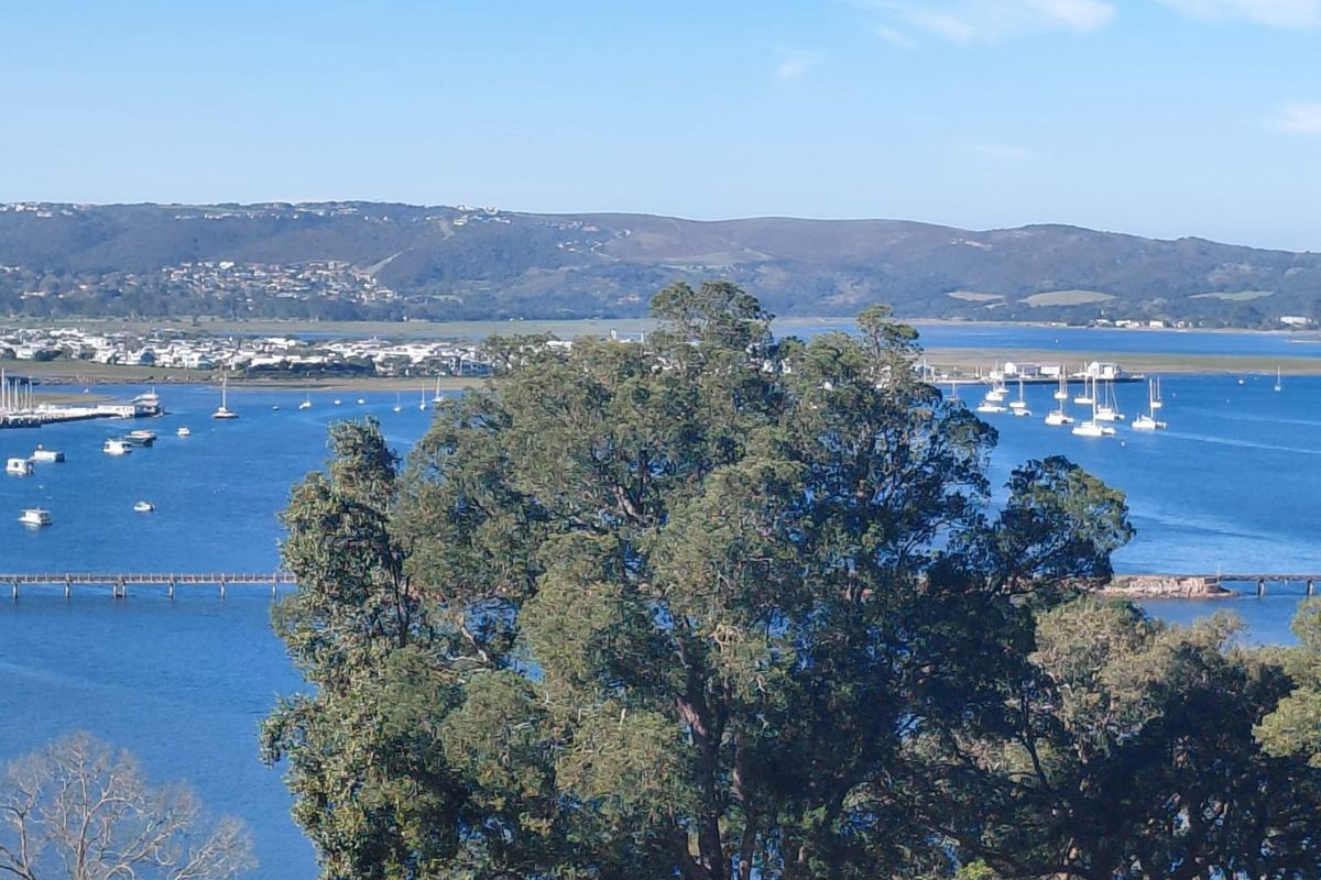 A scenic elevated view overlooking the lagoon, surrounding landscape, and distant coastal residential area.