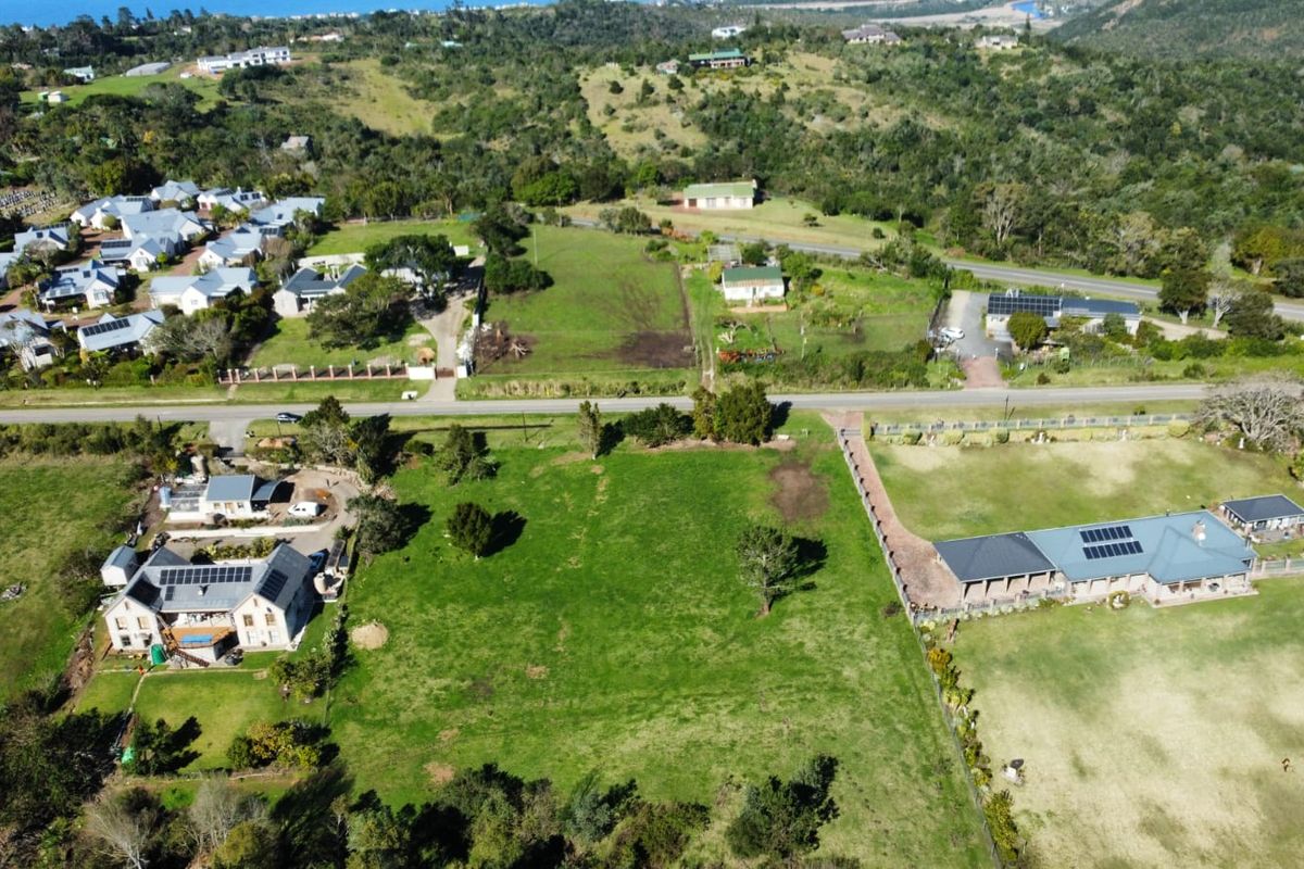 An aerial view of a vacant residential plot situated within an established neighborhood, featuring surrounding homes and clear access.