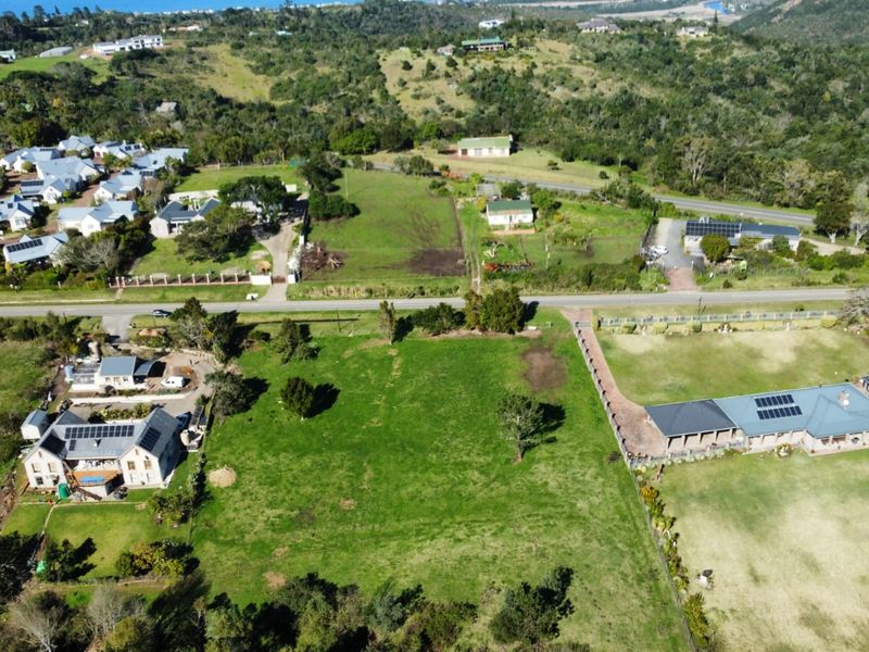 An aerial view of a vacant residential plot situated within an established neighborhood, featuring surrounding homes and clear access.