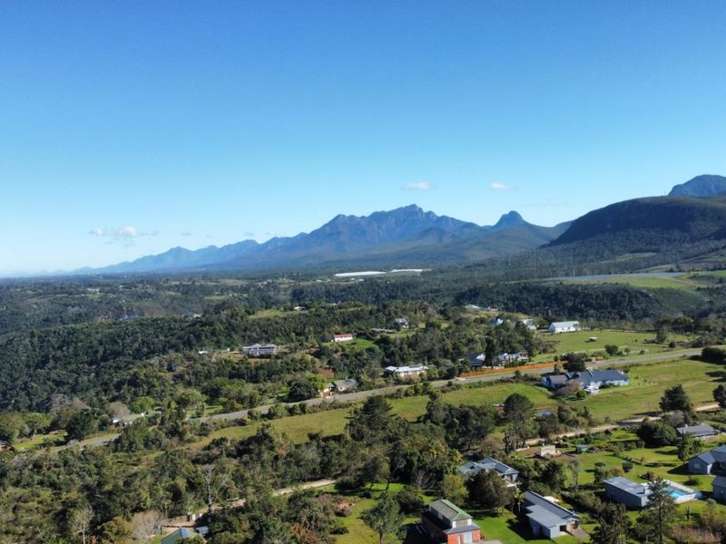 An aerial view of the residential area showcasing the surrounding landscape and mountain range.