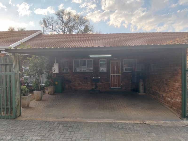 A covered carport area featuring brick paving, exposed brick walls, and a functional utility sink, providing secure off-street parking.