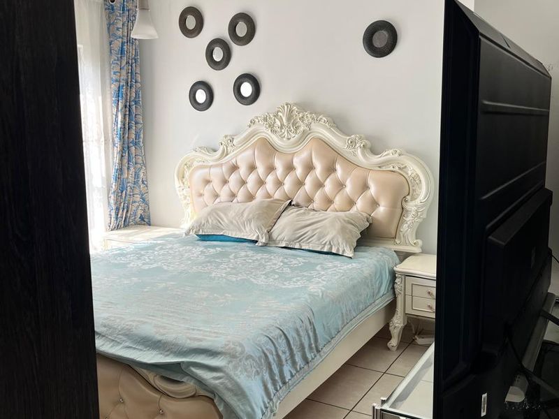 A bedroom featuring tiled flooring and a central ceiling light fixture, viewed from the doorway.