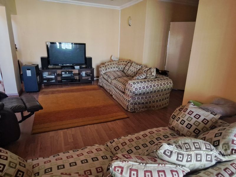 A spacious living room featuring laminate flooring and coving, providing a comfortable and functional area for relaxation.