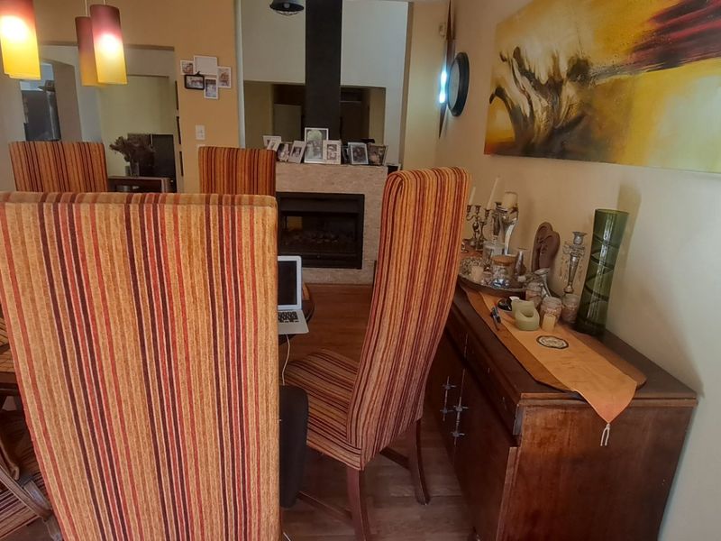 Open plan dining area featuring a built-in fireplace and laminate flooring, with a view into the adjacent kitchen space.