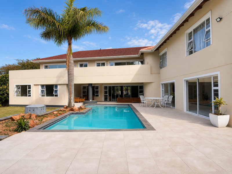 Spacious rear exterior featuring a swimming pool, large tiled patio area, and multiple sliding glass doors providing seamless indoor-outdoor flow.