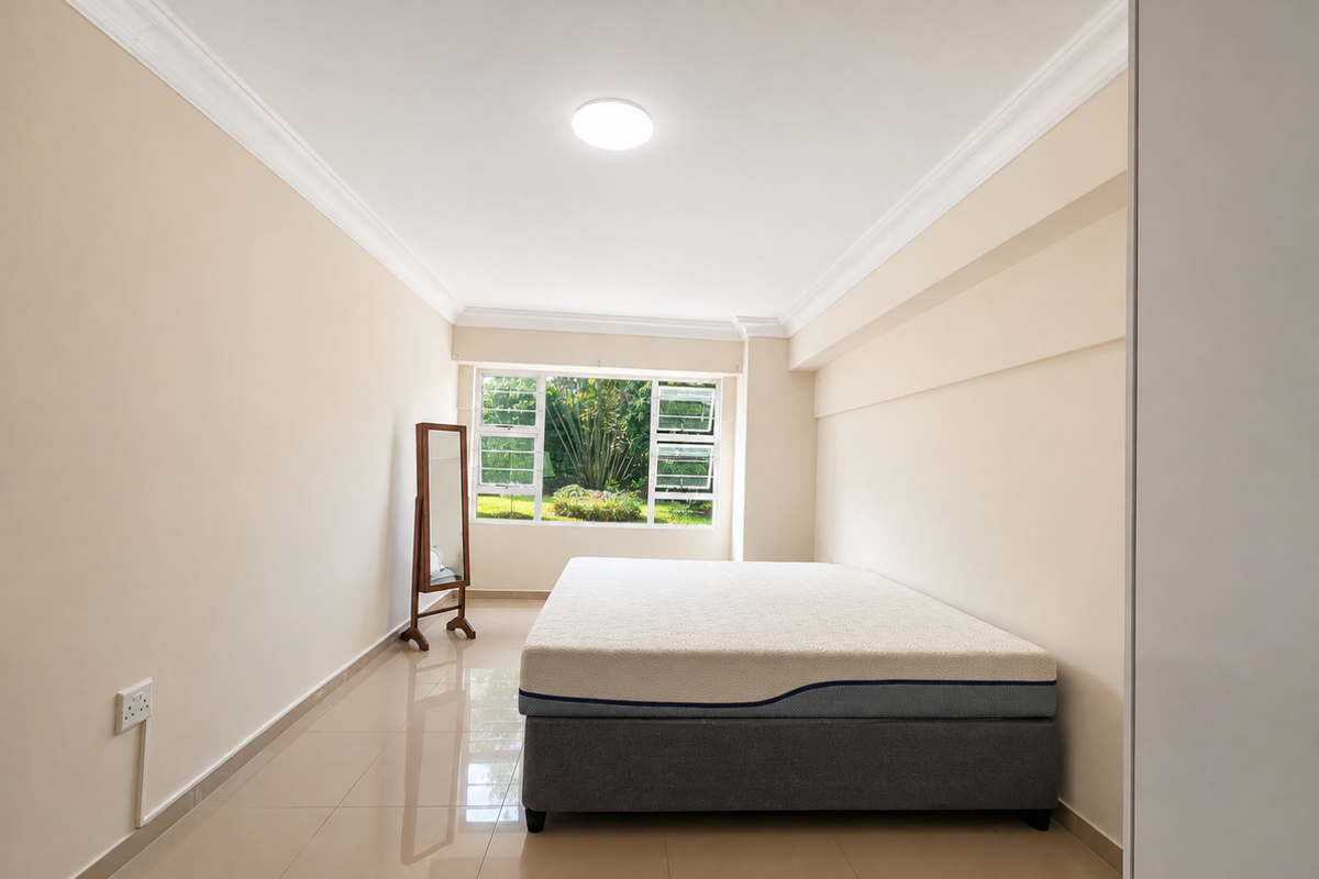 A bright and spacious bedroom featuring neutral walls, tiled flooring, crown molding, and a large window overlooking the garden.