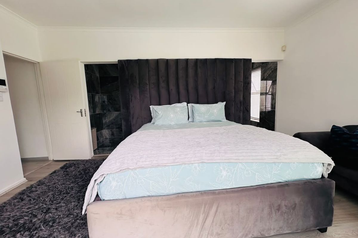 A well-maintained bedroom featuring laminate flooring, coving, and a neutral interior finish, providing a comfortable and functional living space.