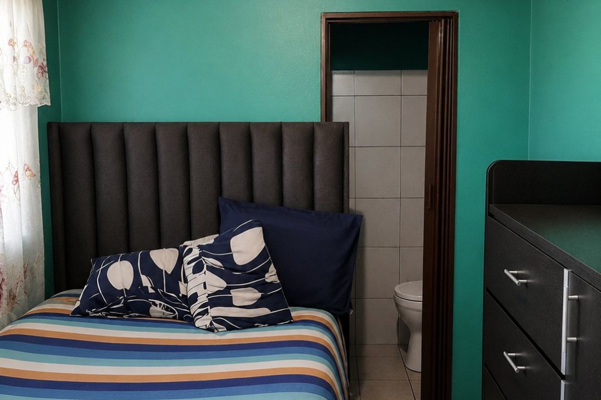A bedroom featuring a timber tongue and groove ceiling, tiled flooring, and direct access to an en-suite bathroom.