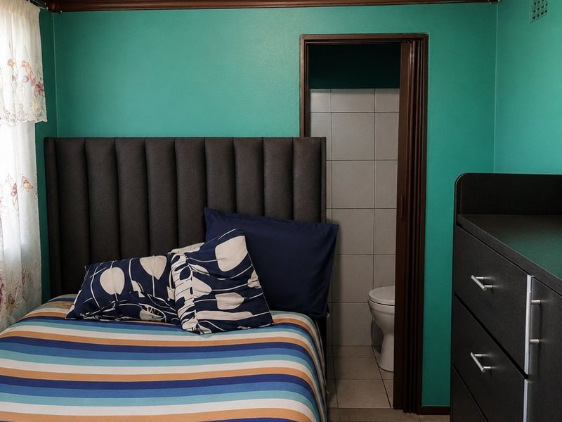A bedroom featuring a timber tongue and groove ceiling, tiled flooring, and direct access to an en-suite bathroom.