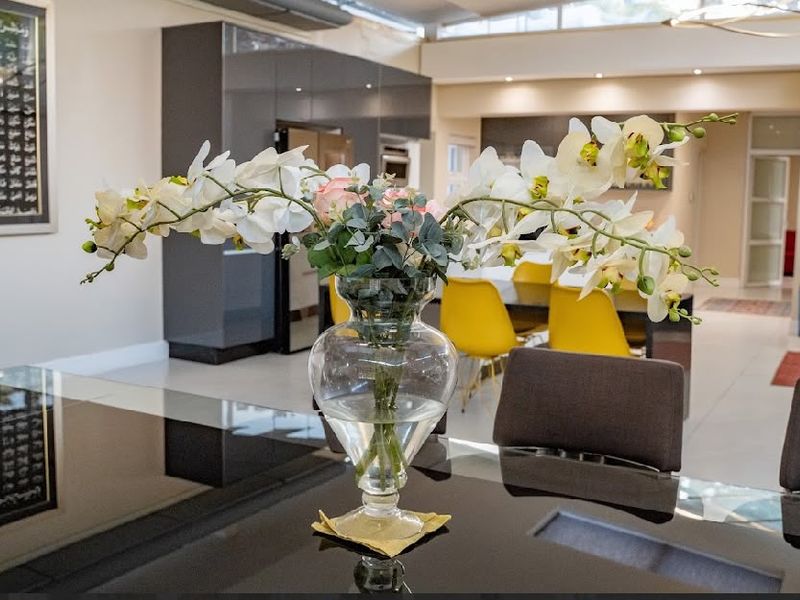 Spacious open-plan living and dining area featuring high-gloss cabinetry, modern tiled flooring, and bright clerestory windows providing ample natural light.