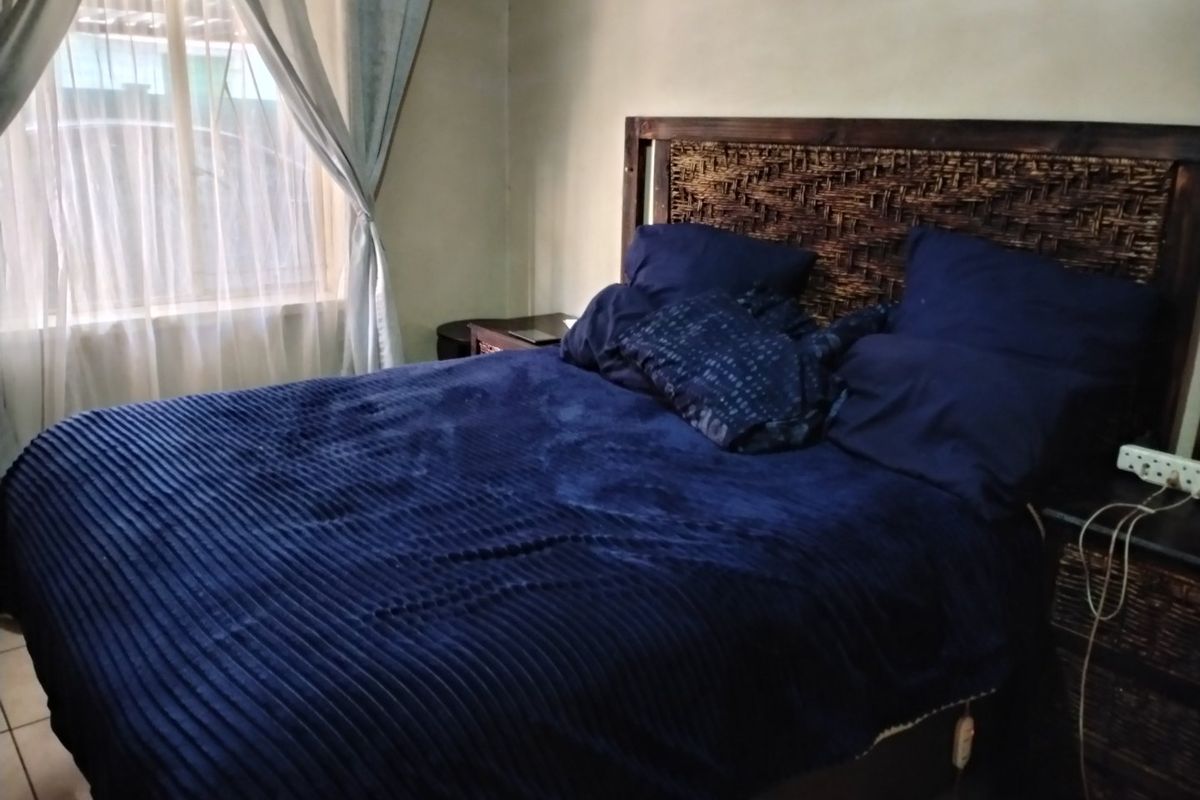 A bedroom featuring tiled flooring and neutral wall finishes, providing a functional space for rest.