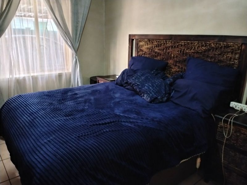 A bedroom featuring tiled flooring and neutral wall finishes, providing a functional space for rest.