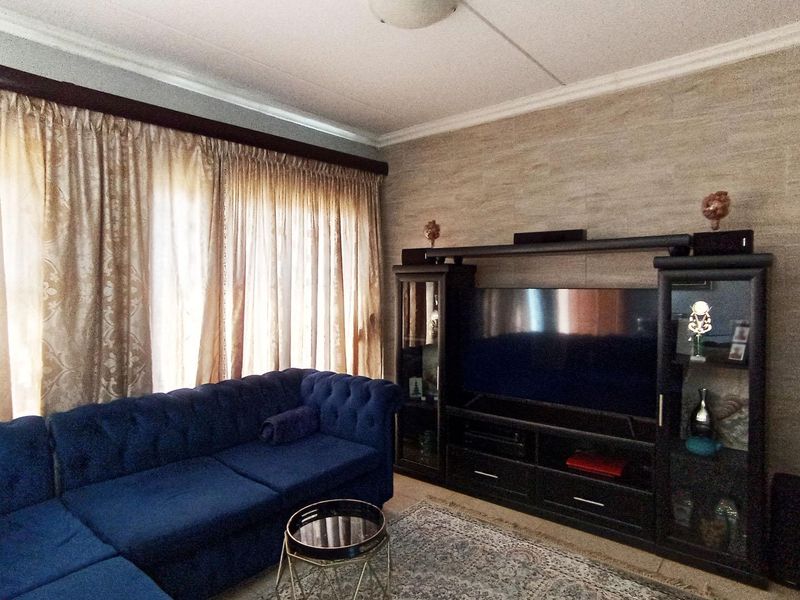 A living room featuring a textured accent wall, ceiling cornice detailing, and a flush mount light fixture.