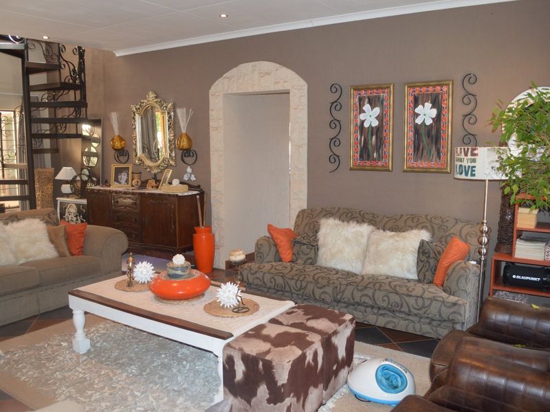 Spacious living room featuring a distinctive spiral staircase, stone-trimmed arched doorway, and tiled flooring, offering a unique architectural layout.