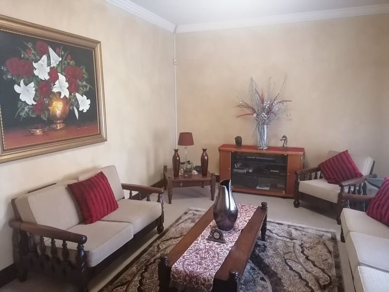 A comfortable living room featuring neutral wall finishes and classic crown molding, providing a warm and inviting space for relaxation.