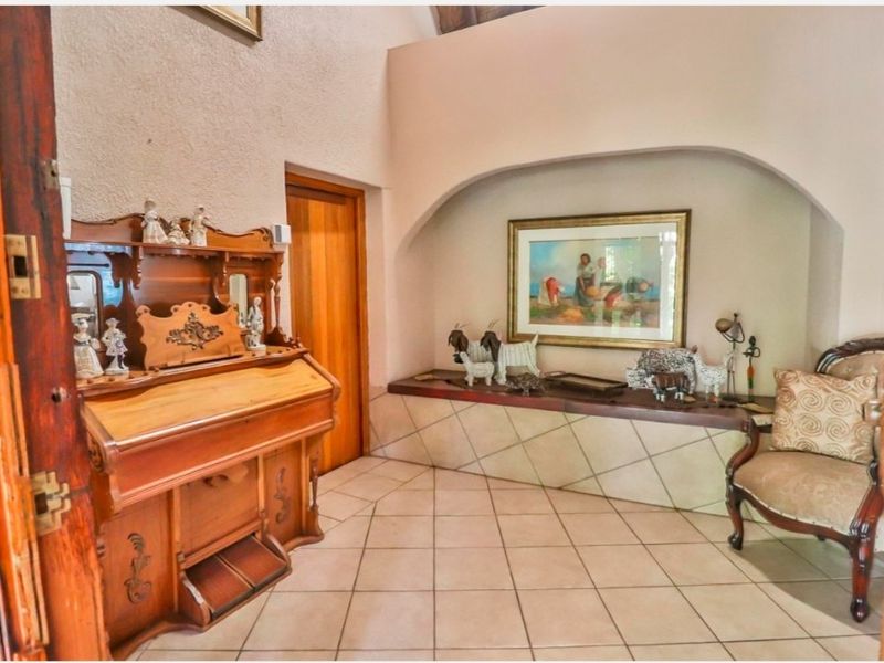 An inviting entrance hall featuring tiled flooring, a distinctive arched wall niche, and a built-in tiled bench area.