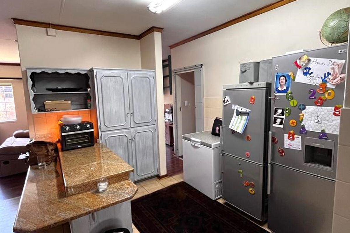 Kitchen area featuring granite countertops, tiled flooring, and built-in cabinetry, offering a functional layout with potential for modern updates.