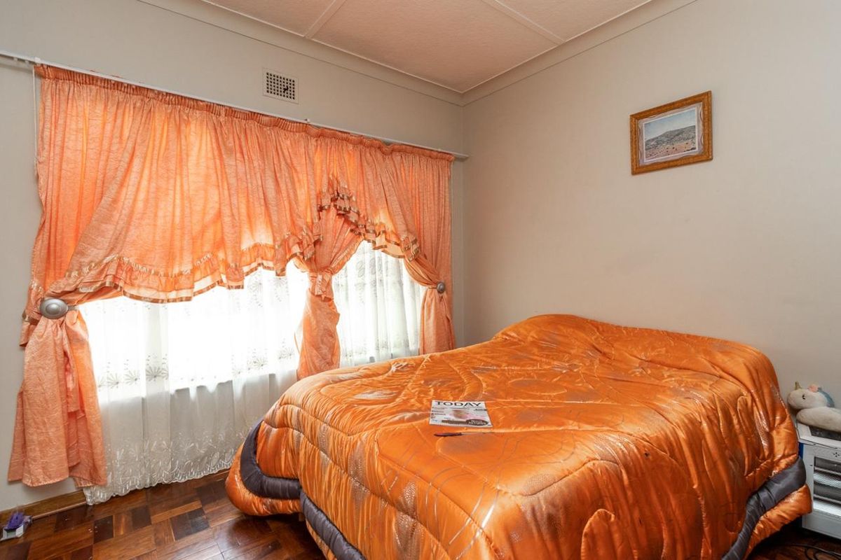 A bedroom featuring classic parquet flooring and a coved ceiling, offering a functional space ready for modern updates.