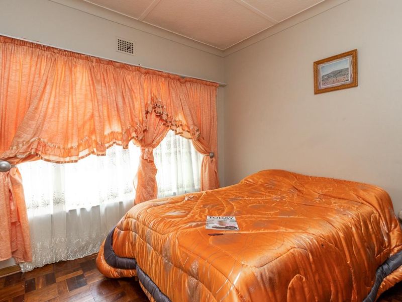 A bedroom featuring classic parquet flooring and a coved ceiling, offering a functional space ready for modern updates.