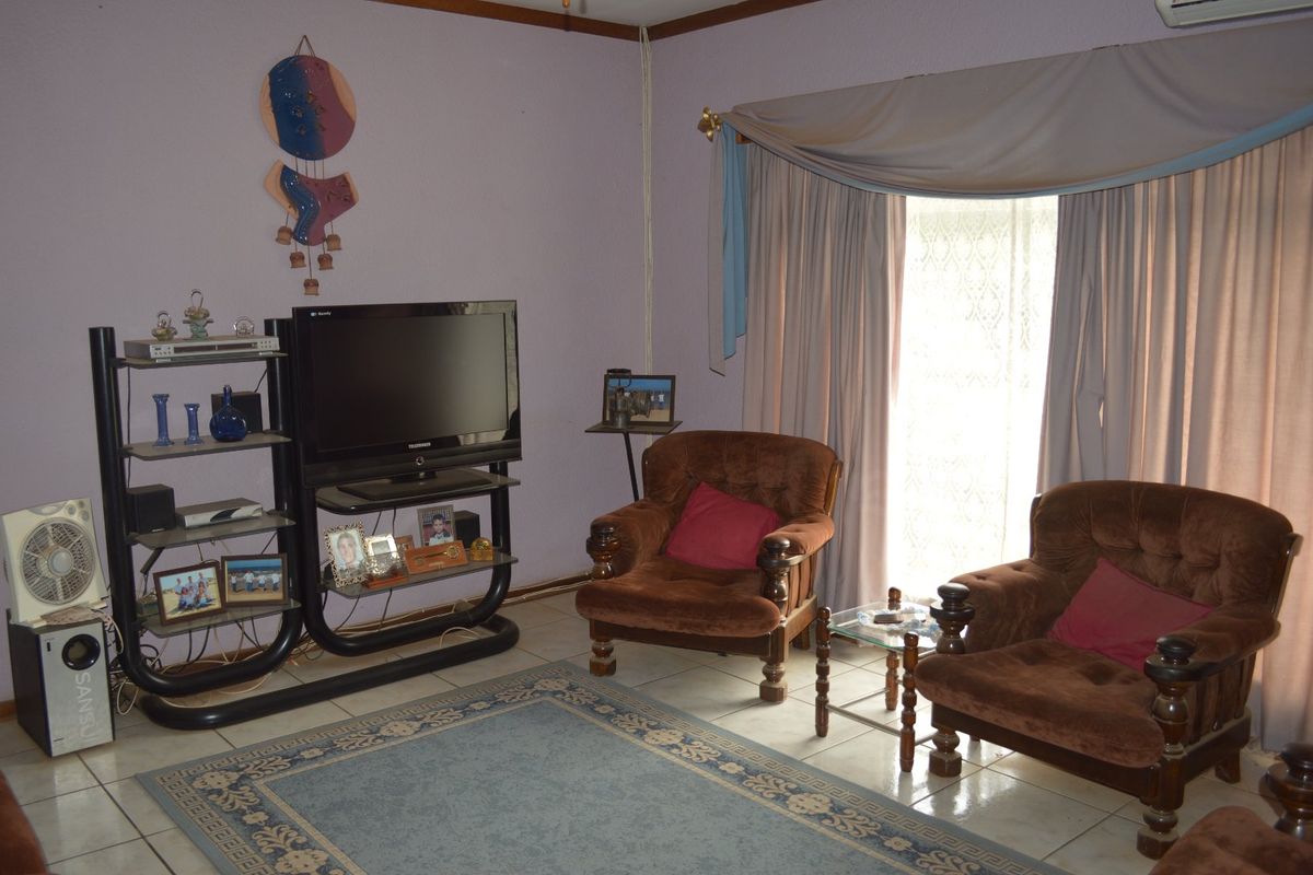 A living room featuring tiled flooring and an installed air conditioning unit, providing a functional space for relaxation.