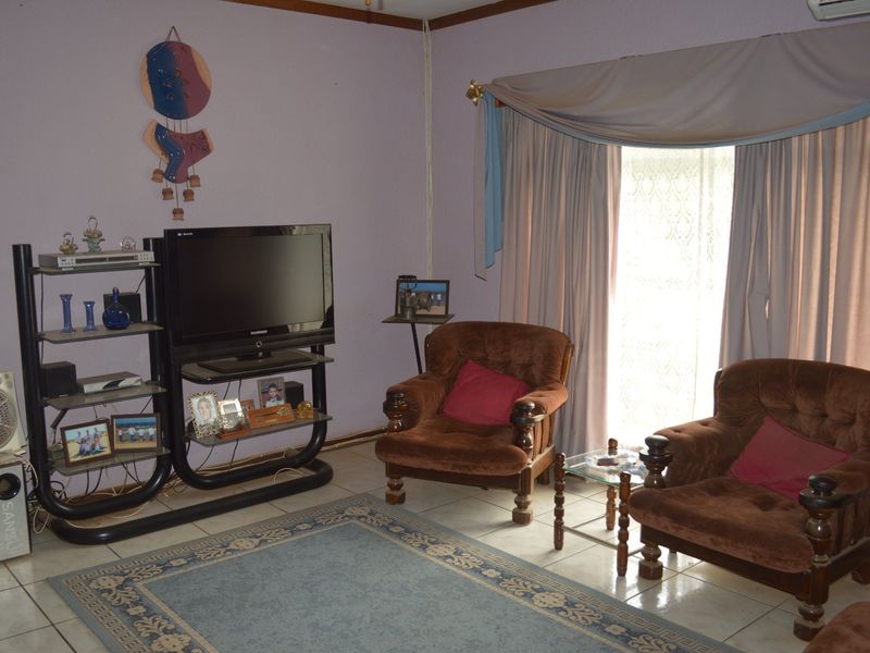A living room featuring tiled flooring and an installed air conditioning unit, providing a functional space for relaxation.