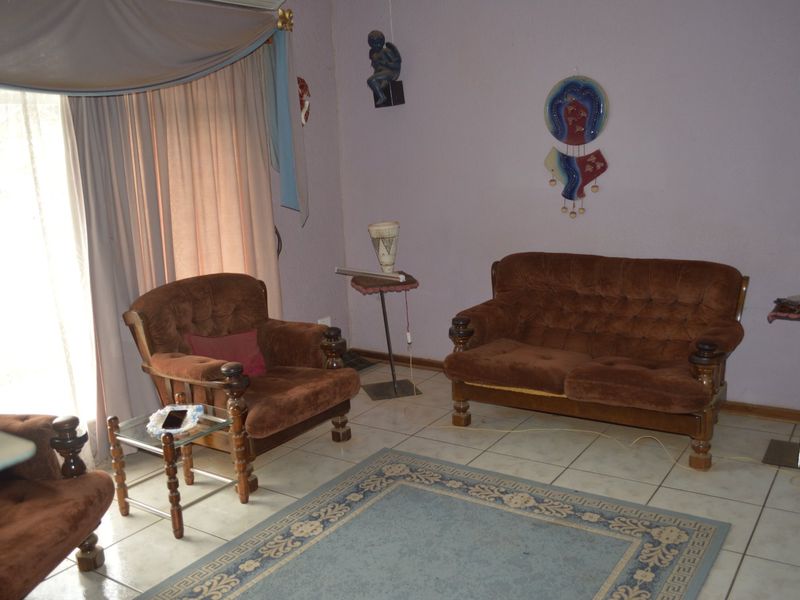 A living room featuring tiled flooring, an air conditioning unit, and a sliding glass door providing access to the exterior.