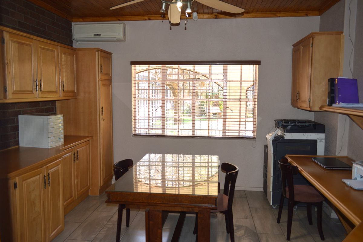 A functional kitchen area featuring wooden cabinetry, tiled flooring, a timber ceiling, and a split-system air conditioner.