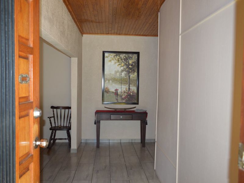 A welcoming entrance hall featuring tiled flooring and a warm timber-paneled ceiling, providing a classic transition into the home.