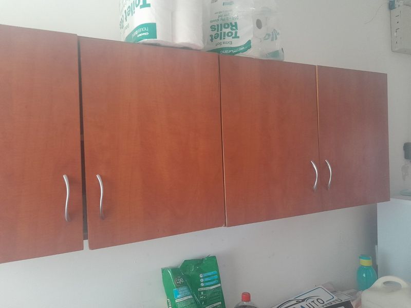 A close-up view of wall-mounted wooden cabinetry providing storage in a utility or service area.