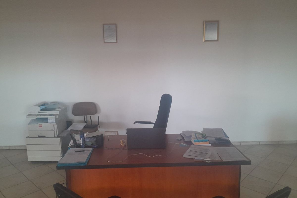 A functional commercial office space featuring tiled flooring and neutral wall finishes, suitable for a professional work environment.