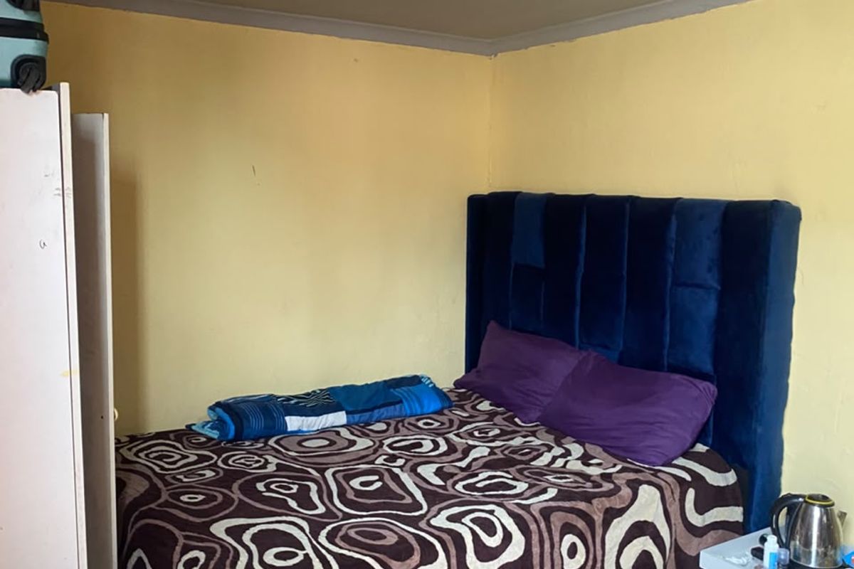A bedroom featuring tiled flooring and recessed ceiling lighting, currently requiring cosmetic updates to the wall finishes.