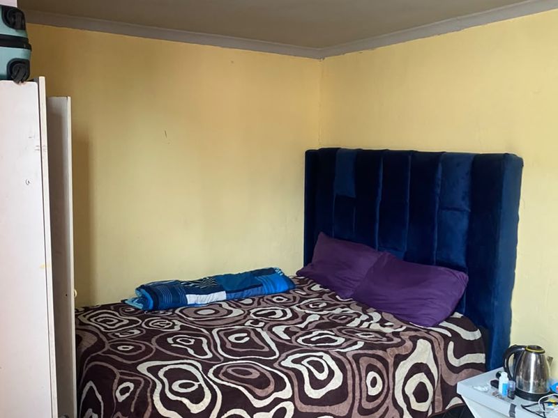 A bedroom featuring tiled flooring and recessed ceiling lighting, currently requiring cosmetic updates to the wall finishes.