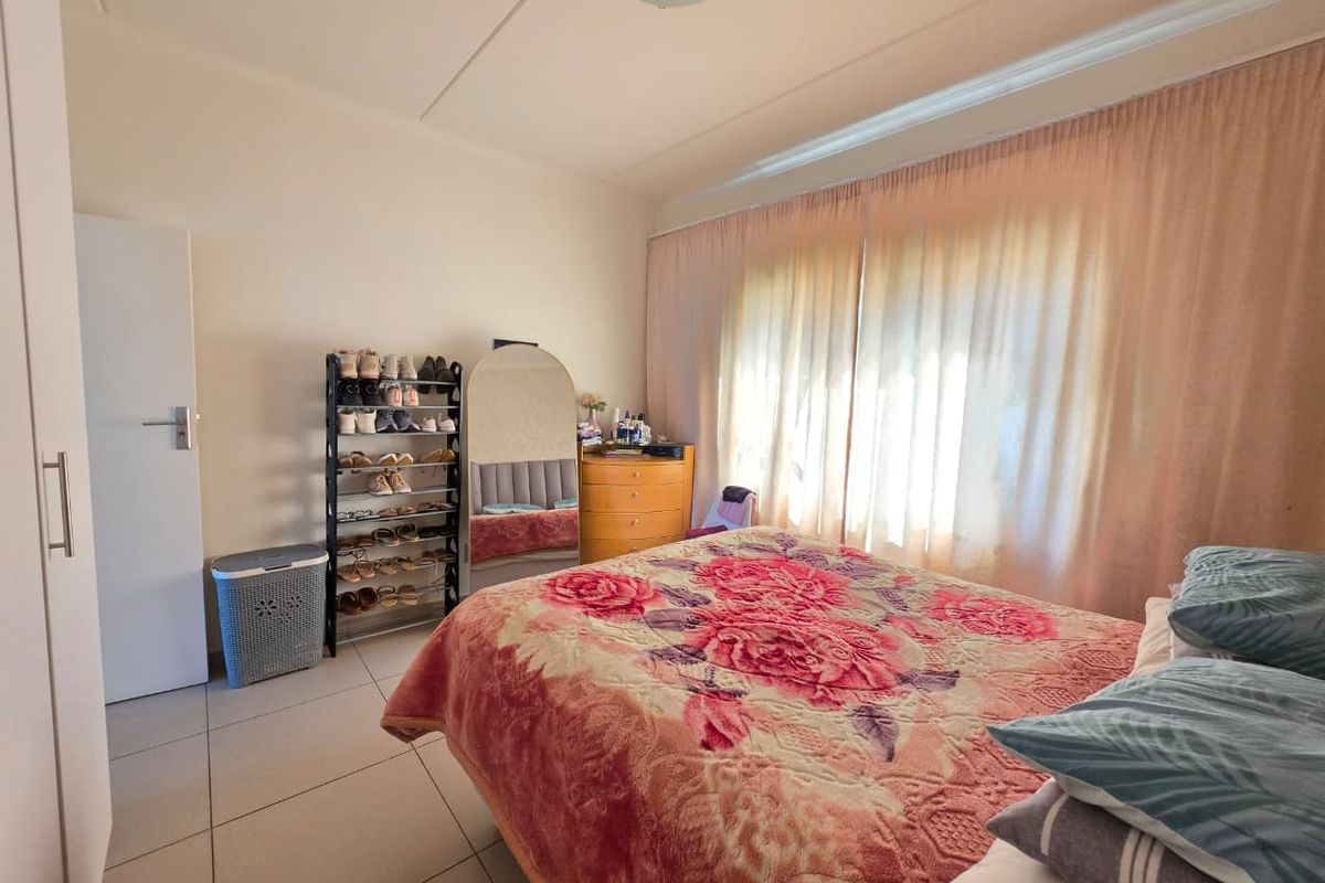 A functional bedroom featuring tiled flooring and a built-in cupboard, offering a neutral base for personalization.