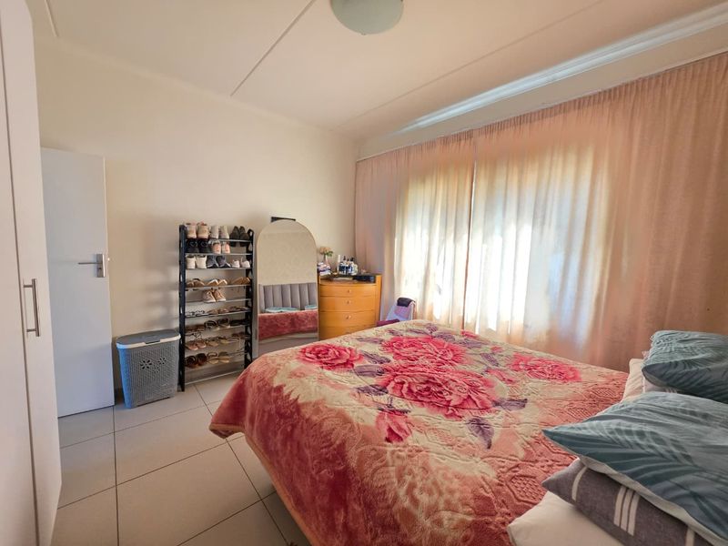 A functional bedroom featuring tiled flooring and a built-in cupboard, offering a neutral base for personalization.