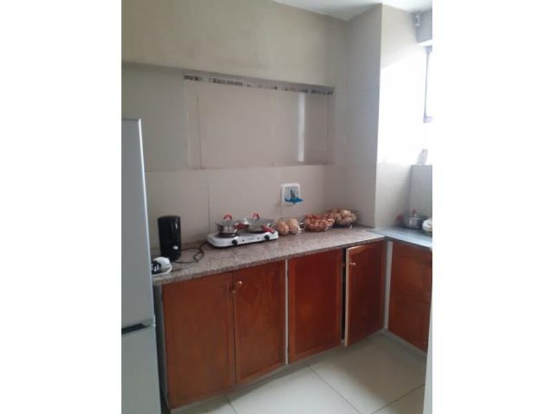 A functional kitchen featuring wooden cabinetry, granite countertops, and tiled backsplash, providing a practical workspace for daily meal preparation.