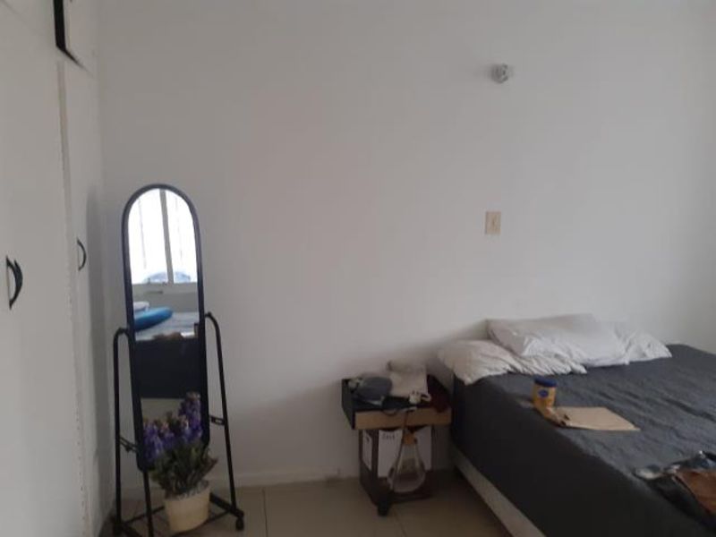 A bedroom featuring built-in cupboards and tiled flooring, offering a functional space ready for personalization.