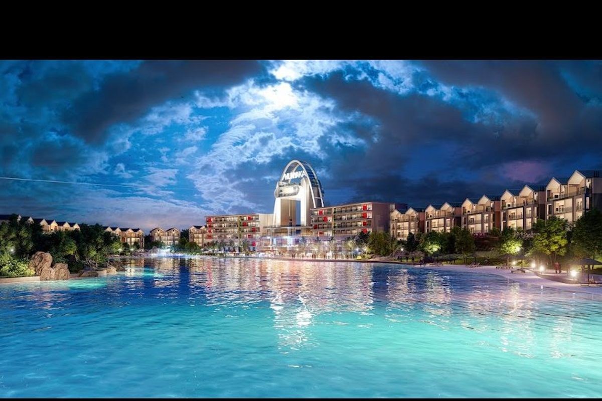 A night view of a large swimming pool area featuring a modern apartment complex and landscaped surroundings.