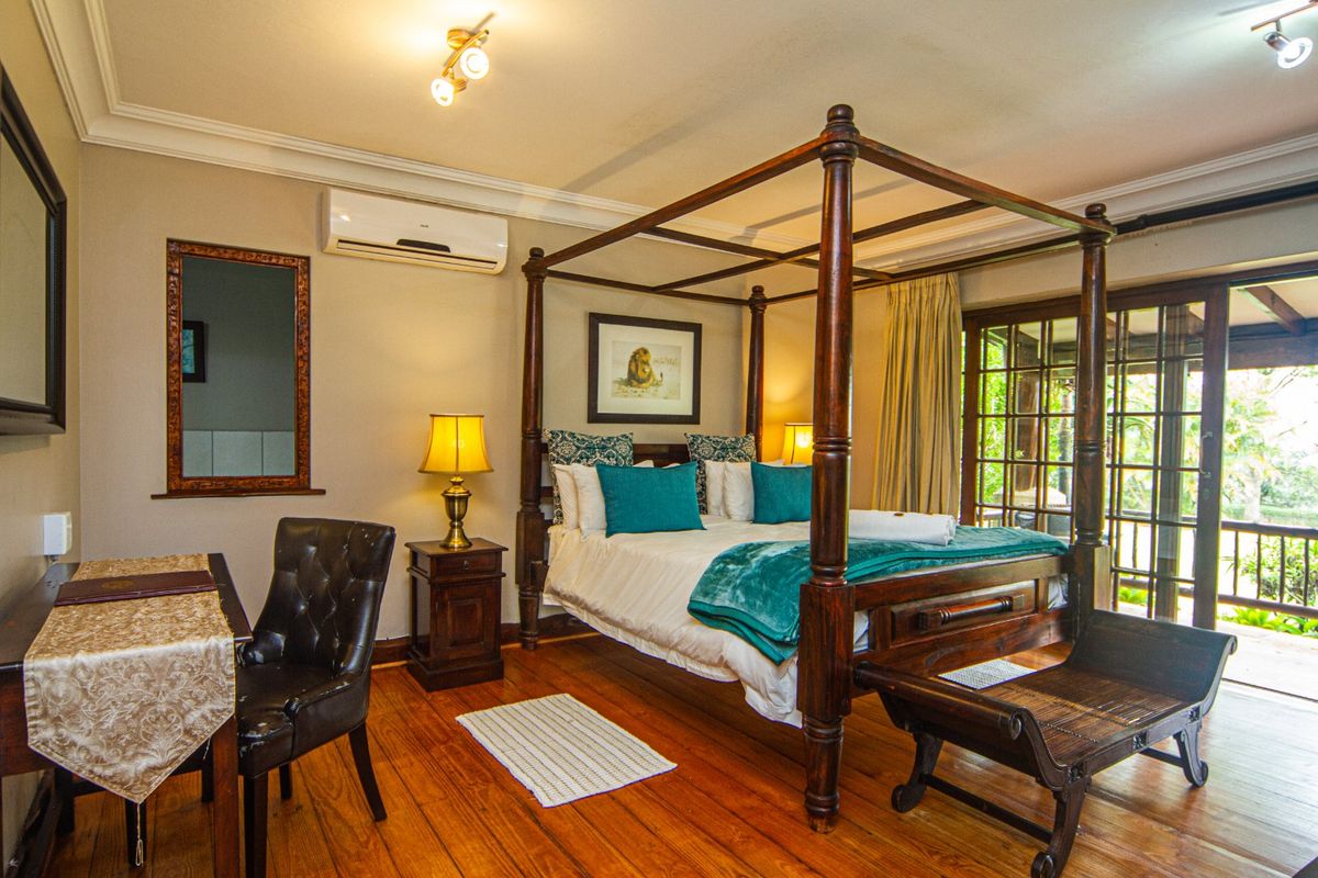 A well-maintained bedroom featuring hardwood flooring, crown molding, a split-system air conditioner, and direct access to an outdoor patio through sliding glass doors.