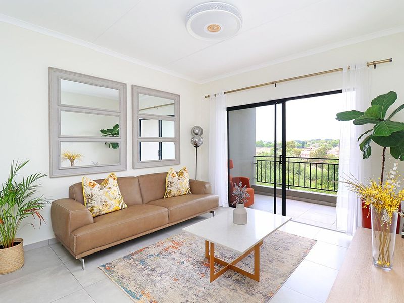 Bright and modern living room featuring neutral tiled floors, a central ceiling light, and large sliding glass doors leading to a private balcony.