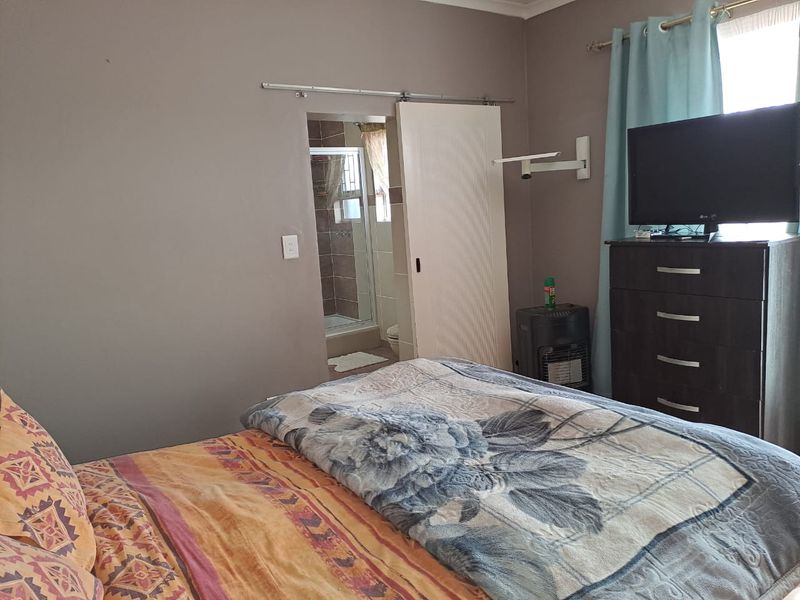 A bedroom featuring a sliding door leading to an en-suite bathroom with tiled finishes.
