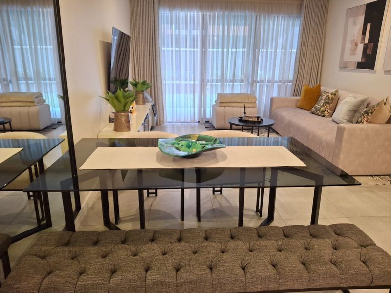 A well-maintained open-plan living and dining area featuring large sliding glass doors that provide ample natural light and access to the outdoor space.