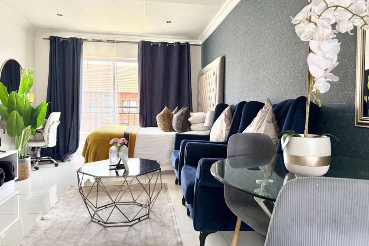 A well-maintained bedroom featuring tiled flooring, recessed lighting, crown molding, and a sliding glass door providing access to an outdoor area.
