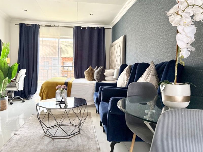A well-maintained bedroom featuring tiled flooring, recessed lighting, crown molding, and a sliding glass door providing access to an outdoor area.