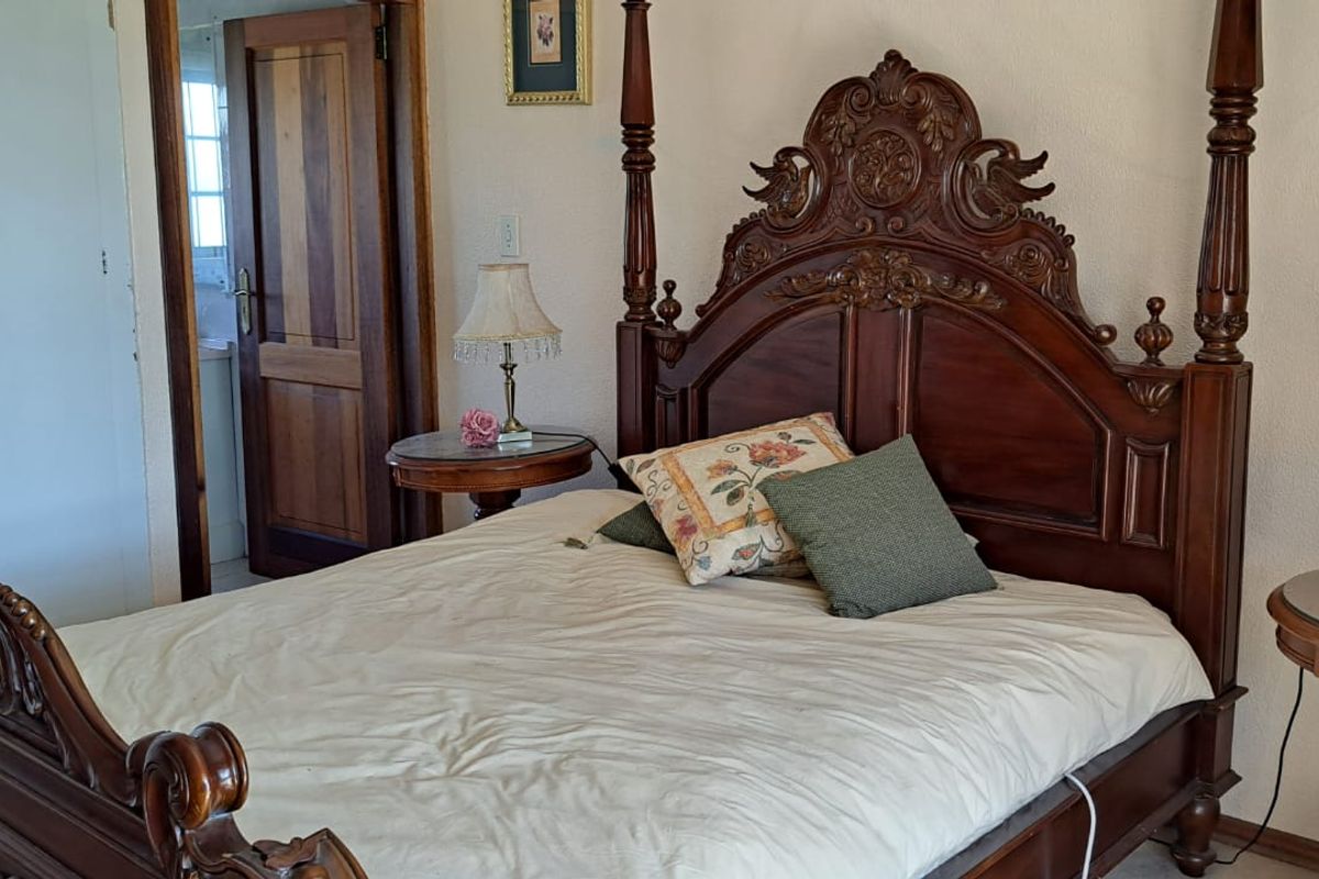 A bedroom featuring built-in cupboards and traditional wooden door finishes, requiring minor cosmetic updates to the wall surfaces.