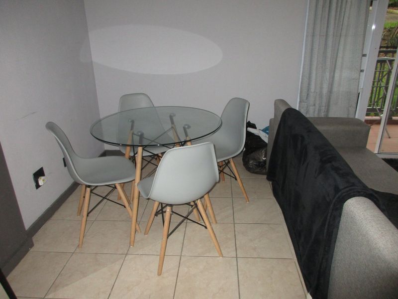 A living area featuring tiled flooring and a sliding glass door leading to an outdoor space.