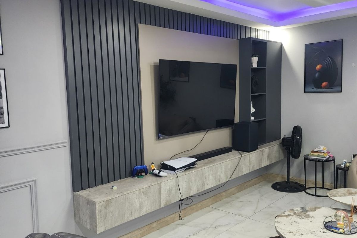 Modern living room featuring a custom slatted feature wall, floating media console, built-in shelving, and ambient LED ceiling lighting.