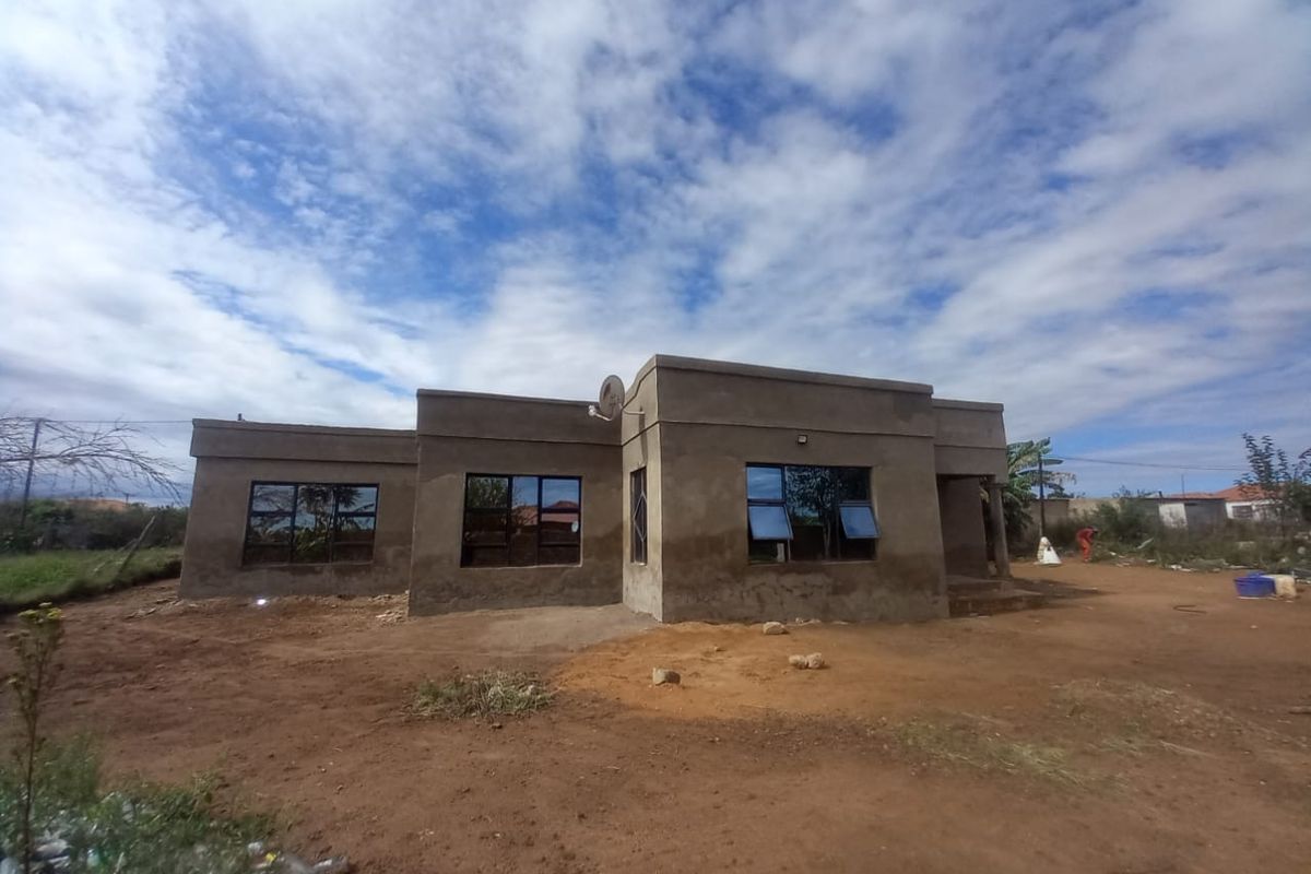 A single-story residential property under construction, featuring plastered exterior walls and installed aluminium window frames, set on an unlandscaped plot.